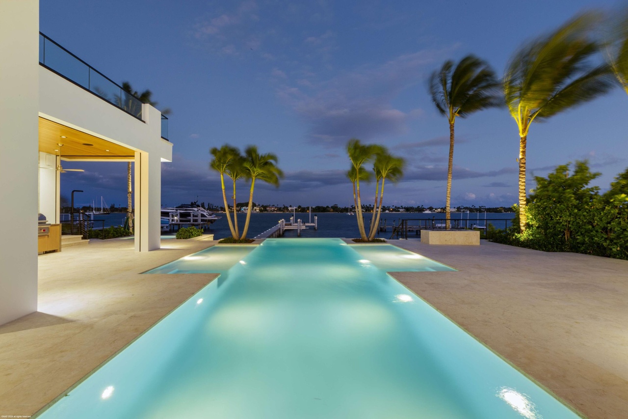 Covered outdoor living space connected to the pool deck and private dock.
