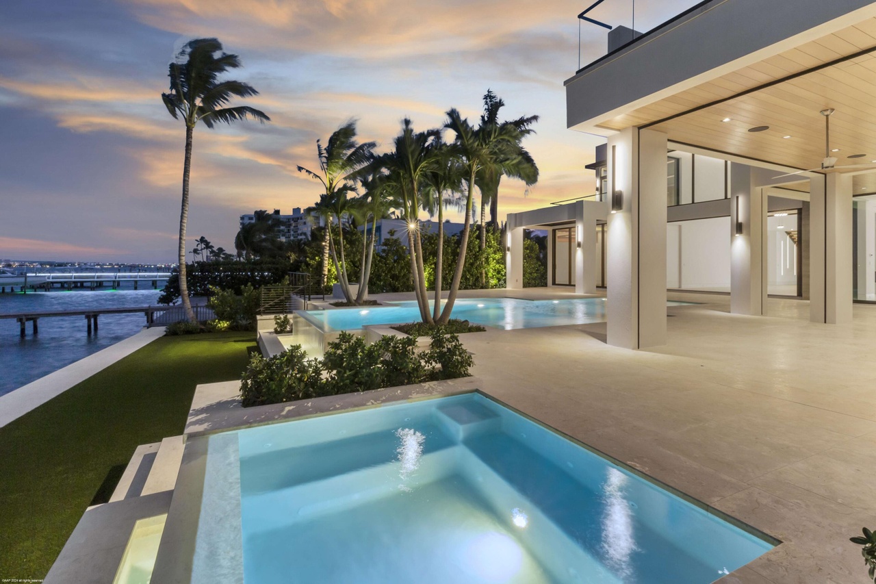 Waterfront primary suite terrace with open sky and layered views.
