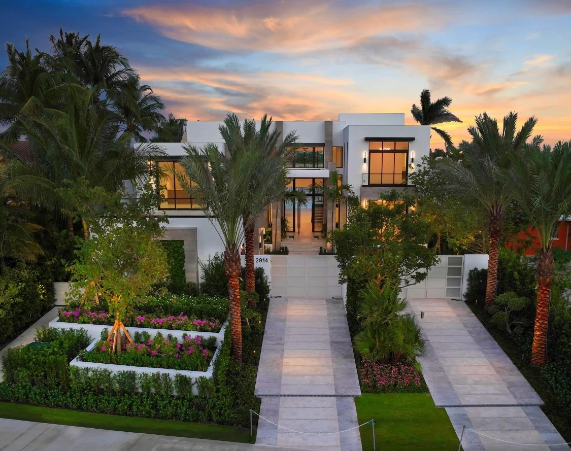 Modern luxury home exterior at dusk with calm architectural lighting.